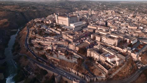 An-upward-drone-shot-of-Toledo,-its-alcazar-and-its-cathedral-at-sunrise