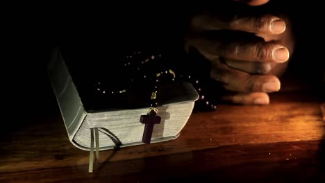Beten-Zu-Gott-Mit-Den-Händen-Zusammen-Mit-Bibel-Und-Kreuz-Karibischer-Mann-Beten-Mit-Schwarzem-Hintergrund-Stock-Video