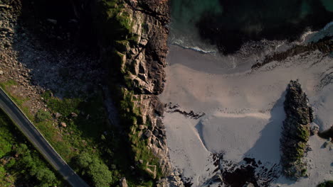 Beautiful-sandy-beach-with-contrast-between-turquoise-sea-and-rocks,-Aerial-Birdseye-shot,-Andoya,-Vesteralen