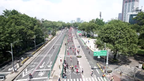 rotational-drone-shot-of-the-runners-of-the-city-marathon-as-they-pass-through-the-central-median