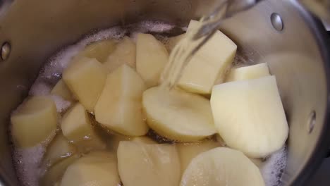 Kochendes-Wasser-Wird-Auf-Geschnittene-Kartoffeln-Gegossen,-Die-In-Einer-Pfanne-Kochen