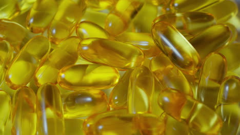 Closeup-Omega-3-fish-oil-pills-drops-on-the-white-background,-vitamin-E-natural-capsules-texture