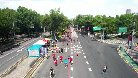 backwards-drone-shot-of-the-runners-of-the-city-marathon-as-they-pass-through-the-inner-circuit