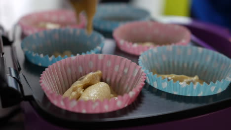 Adding-cake-mixture-to-paper-cupcakes-trays-for-baking