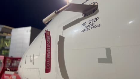 Close-view-of-a-medium-size-jet,-with-pitot-cover-and-“remove-before-flght”-red-label-waving