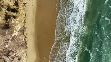 Flying-above-sand-dunes-and-white-sandy-beach-during-rising-tide
