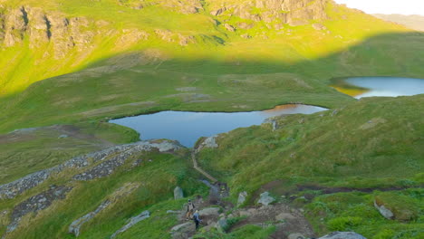 Two-tourist-walking-down-the-hiking-trail-in-a-breathtaking-landscape-of-Lofoten-Island