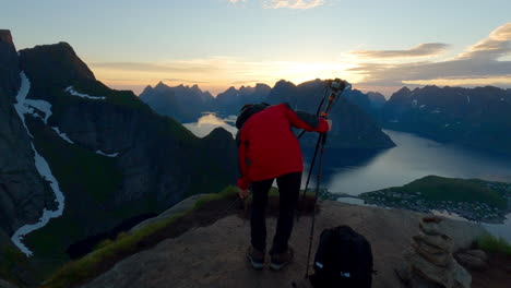Asian-tourist-setting-up-his-camera-on-a-scenic-peak-of-Reinebringen-to-take-photos