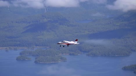 Small-Private-Airplane-Flying-Above-Lakes-and-Forest,-Air-to-Air-View