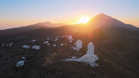Atemberaubende-Kreisende-Luftaufnahme-Um-Weiße-Observatorien-In-Den-Bergen-Auf-Teneriffa,-Spanien,-Sonnenuntergang-Im-Hintergrund