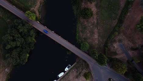 Birds-eye-view,-coming-down-shot-above-river-bridge-of-a-car-crossing-in-the-countryside,-Great-Bartford,-St-Neots,-Cambridgeshire,-Uk