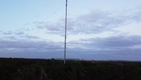 Low-to-high-drone-aerial-shot-of-a-radio-tower-in-Deepdale,-Sandy,-Bedfordshire,-Uk