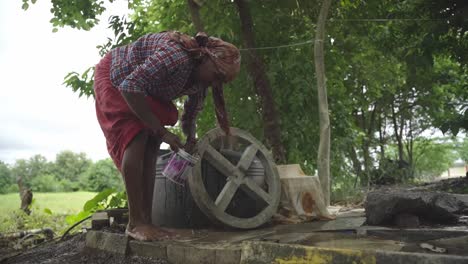 Low-angle-shot-of-an-Indian-village-woman-washing-her-feet-after-working-in-the-farmland