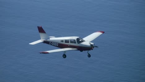 Single-Engine-Propeller-Aircraft-Flying-Above-the-Sea,-Air-to-Air-View