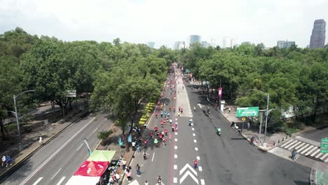 backwards-quick-drone-shot-of-the-runners-of-the-city-marathon-as-they-pass-through-the-great-avenues