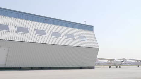 Airfield-Hangar-Doors-Opening-Revealing-Parked-Twin-Engine-Airplane