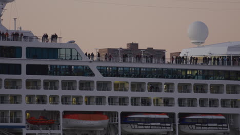 Passagiere,-Die-Während-Der-Goldenen-Stunde-Auf-Dem-Oberdeck-Des-Kreuzfahrtschiffes-Stehen,-Wenn-Es-In-New-York-Ins-Dock-Kommt