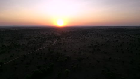 Sunset-at-African-Serengeti-terrain-seen-from-above,-Aerial-flyover-dolly-left-shot