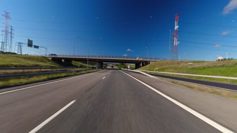 POV-blue-sky-drive-through-several-overpasses-on-suburban-highway