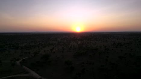 Sunset-landscape-of-African-Serengeti-terrain,-Aerial-flyover-shot