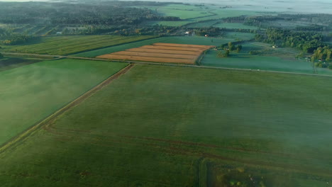 Aerial-wide-view-of-vast-Agricultural-Fields-With-Organic-Crops-shrouded-in-morning-fog