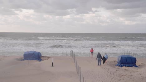 Children-Running-On-Beautiful-Windy-Beach-In-De-Haan,-Belgium---wide,-slow-motion