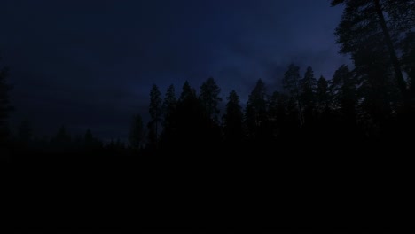 Campfire-smoke-in-darkening-northern-forest-sky-as-day-turns-to-night