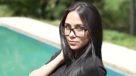 Beautiful-Green-Eyed-Latina-Woman-with-Glasses-Sitting-Poolside