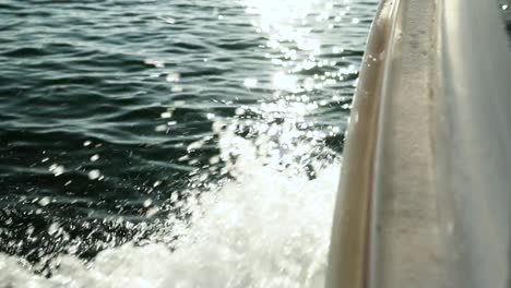 Extreme-close-up-on-boat-bow-sailing-over-sea-water-splashes-on-a-sunny-day