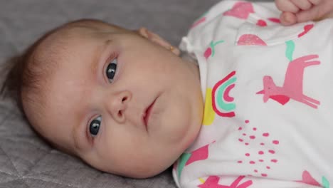 Babymädchen-Hautnah-Auf-Der-Seite-Liegend,-In-Die-Kamera-Schauend,-Gesichtsausdrücke-Machend