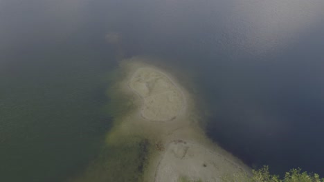 Drone-descending-"landing-into-water"-in-"Velpker-Schweiz"-natural-park-in-Germany---old-Quarrys-filled-with-water