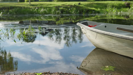 Single-rowboat-on-a-calm-river-with-water-moving-slowly-on-a-sunny-summer-day