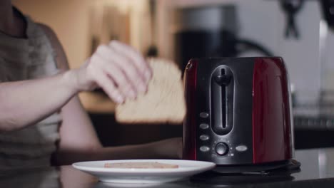 a-caucasian-female-model-puts-slices-of-bread-in-a-toaster---slow-motion-shot