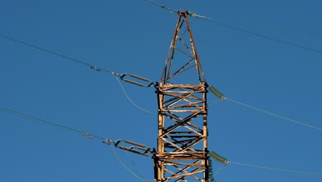 Stromleitungen-Mit-Sonnenstrahlen-Am-Blauen-Himmel