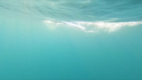 Punto-De-Vista-Subacuático-Nadando-Rápido-Bajo-Los-Remos-De-Un-Bote-De-Remos