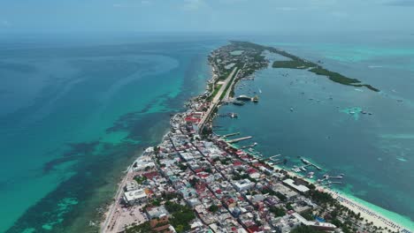 Aerial-view-over-the-town-on-the-Isla-Mujeres-island-in-sunny-Mexico---rising,-pull-back,-drone-shot