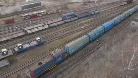 Aerial-view-of-Train-slowing-riding-next-to-industrial-area---flying-with-the-train