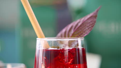 Slow-motion-of-falling-ice-cube-into-a-cup-of-red-herbal-tea