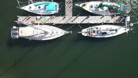 Overhead-Drohnenaufnahmen-Von-Segelbooten-In-Der-Marina,-Die-Entlang-Des-Docks-Verfolgen