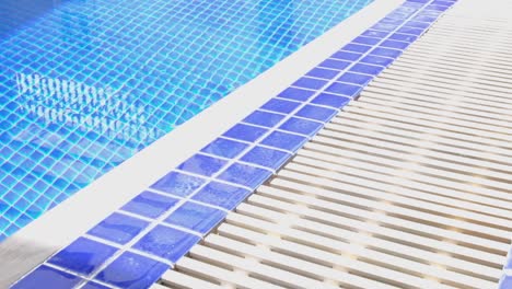 Ceramic-blue-tiles-in-swimming-pool-at-relaxing-vacation-destination-with-inviting-cool-crystal-clear-water,-close-up
