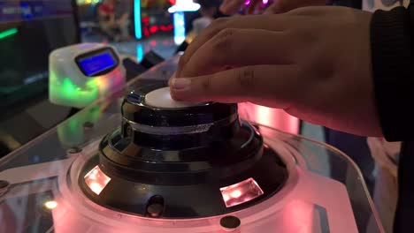 Nahaufnahme-Der-Hände,-Die-Den-Leuchtenden-Knopf-Des-Japanischen-Arcade-Spiels-Mit-Rhythmischer-Musik-Drücken