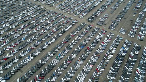 Many-cars-on-a-parking-lot-from-above,-filmed-with-a-drone