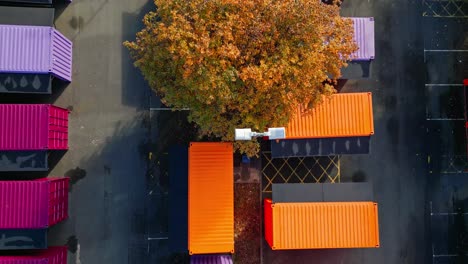Aerial-footage-of-multicolored-porta-cabins,-market-stalls,-steel-cabins,-storage-units,-shot-from-directly-above-and-moving-slowly-backwards