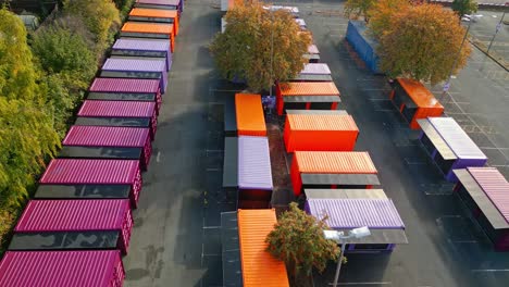 Aerial-footage-of-multicolored-porta-cabins,-market-stalls,-steel-cabins,-storage-units,-shot-from-above-and-moving-slowly-forwards
