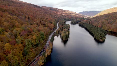aerial-push-in-roadway-by-lake-in-vermont-in-fall-and-autumn