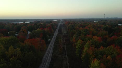 Forward-track-of-a-railroad-section-lined-with-trees-blooming-fall-colors