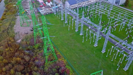 Distributing-high-voltage-power-substation-iviewed-from-above-on-a-block-of-land-made-of-insulators,-poles,-wires-and-transformers
