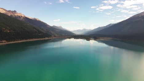 Dolly-Nach-Vorne-Luftaufnahme-Des-Elchsees-Im-Mount-Robson-Provincial-Park-Im-Herbst-Mit-Gelben-Bäumen-Und-Bergen-Im-Hintergrund-Und-Autos,-Die-Auf-Der-Autobahn-Mit-Grünblauem-Wasser-Fahren