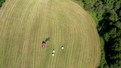 Aerial-Birds-Eye-View-Of-Tractor-Turning-Around-On-Green-Field-In-Chmielno