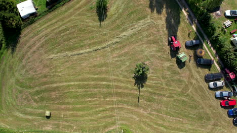 Aerial-view-flying-above-lawnmower-tractor-landscaping-grass-field-in-Chmielno,-Poland